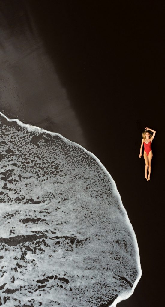 Chica en una playa de arena negra en Madeira