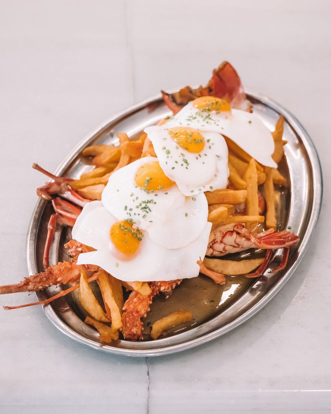 Huevos fritos con patatas y langosta