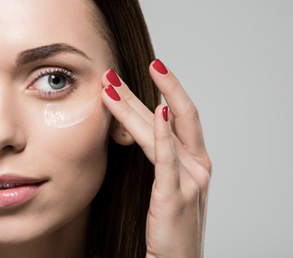 Mujer aplic&aacute;ndose contorno de ojos
