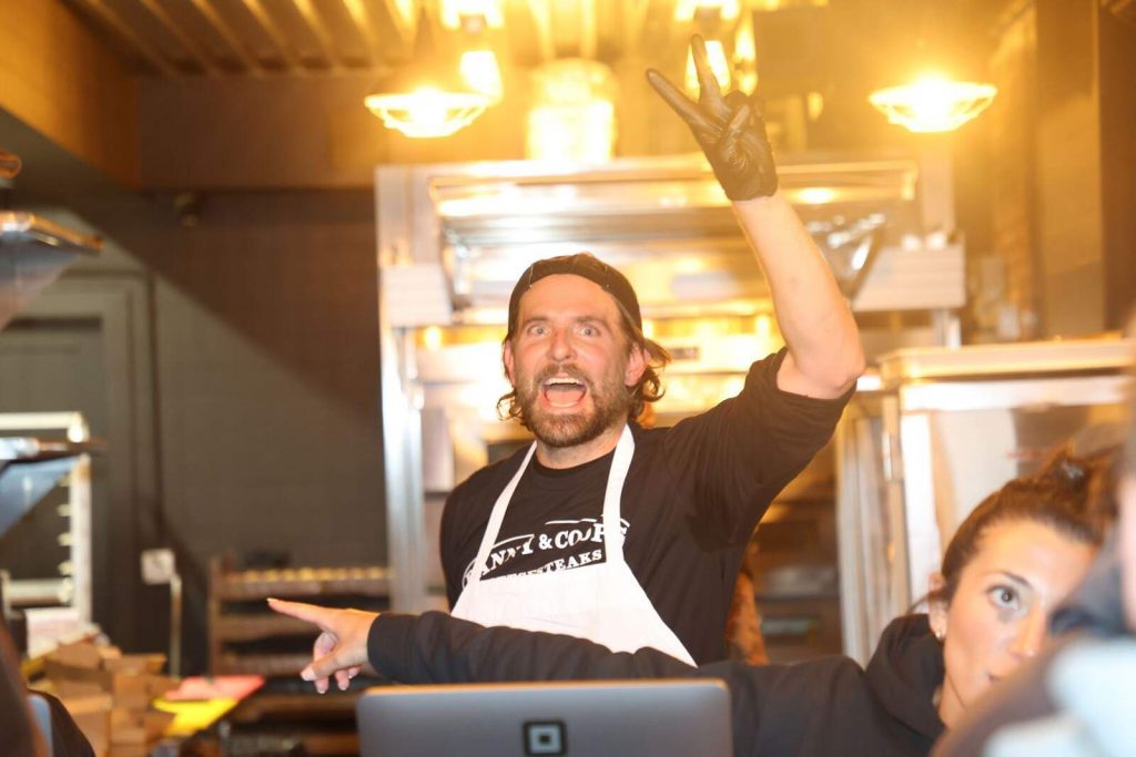 Bradley Cooper saludando mientras cocina