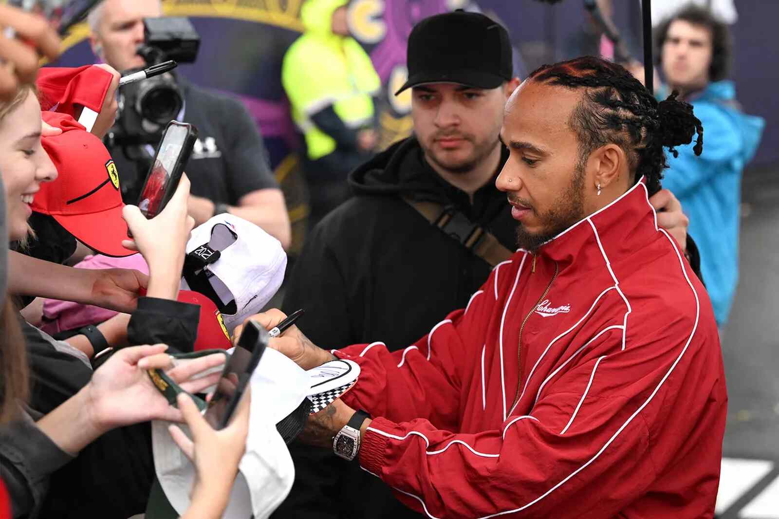 Hamilton firmando autógrafos, relojes Fórmula 1