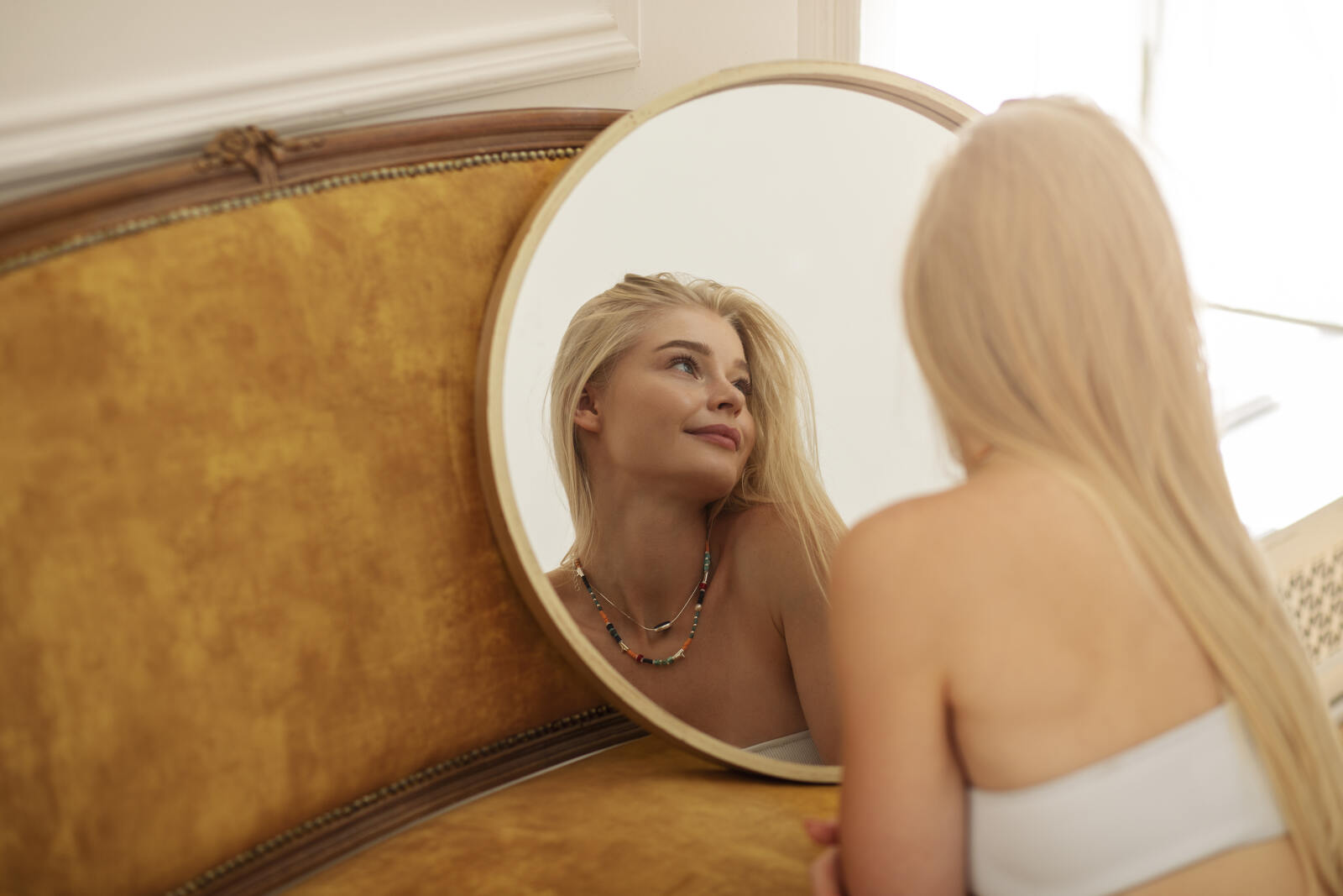 Mujer mir&aacute;ndose al espejo, cirug&iacute;a y salud mental