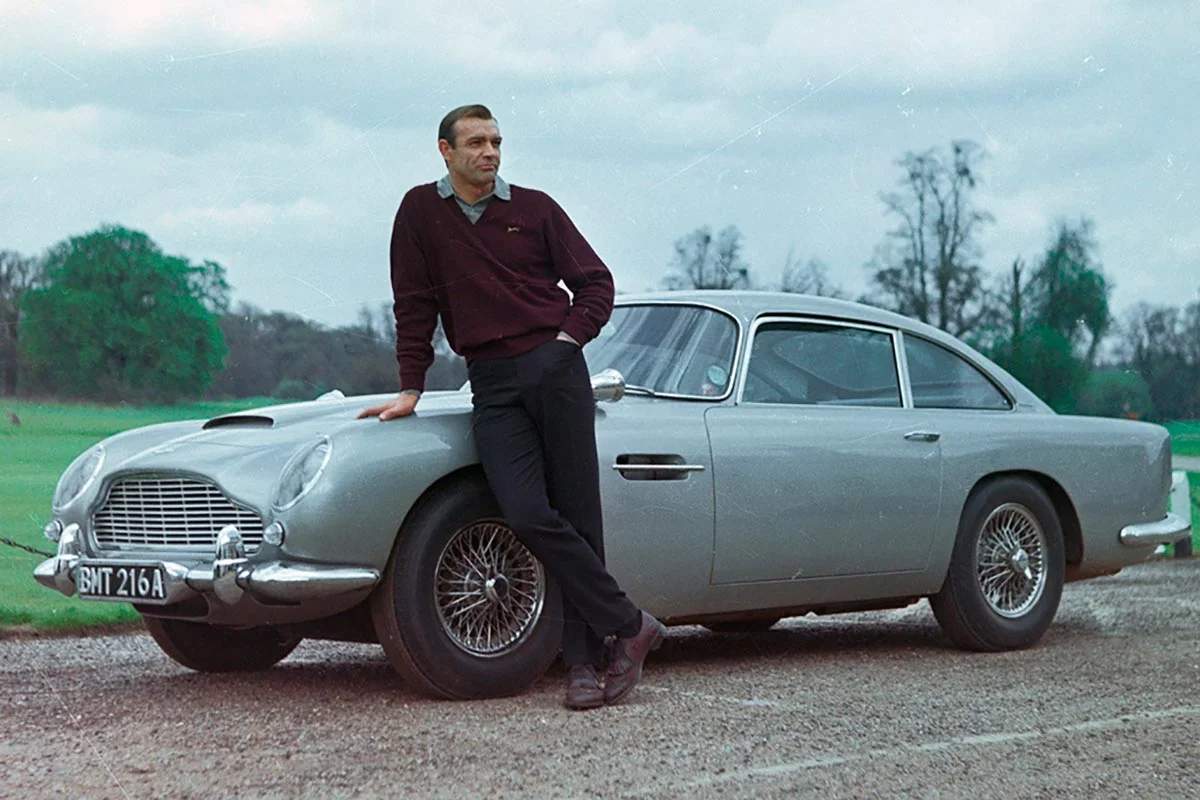 James Bond posando con el Aston Martin DB12