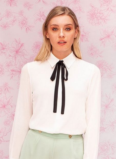 Blusa blanca con lazada 'pussy bow' de la colecci&oacute;n c&aacute;psula de LVRxBimani./Instagram @lavecinarubia