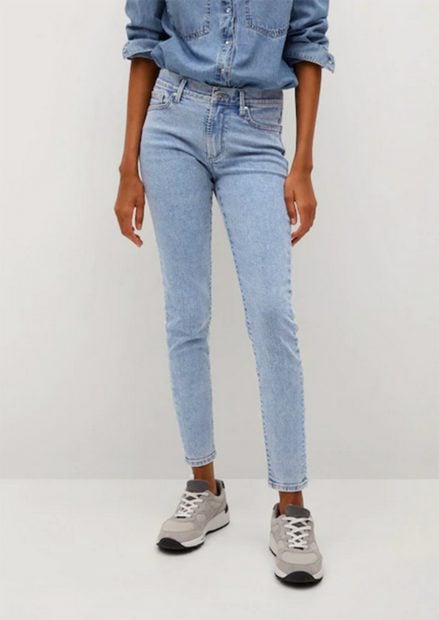Pantalones tejados de tiro medio con bot&oacute;n central en azul desgastado de la firma espa&ntilde;ola Mango./Mango