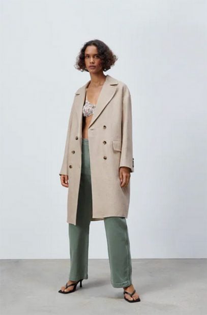 Abrigo de pa&ntilde;o de Zara en color nude abotonado por la parte central con solapas en la parte superior./Zara