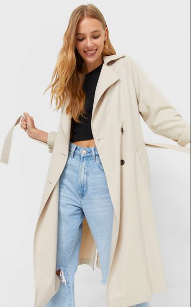 Gabardina de estilo cl&aacute;sico en color beige abotonada y con cintur&oacute;n de Stradivarius./Stradivarius