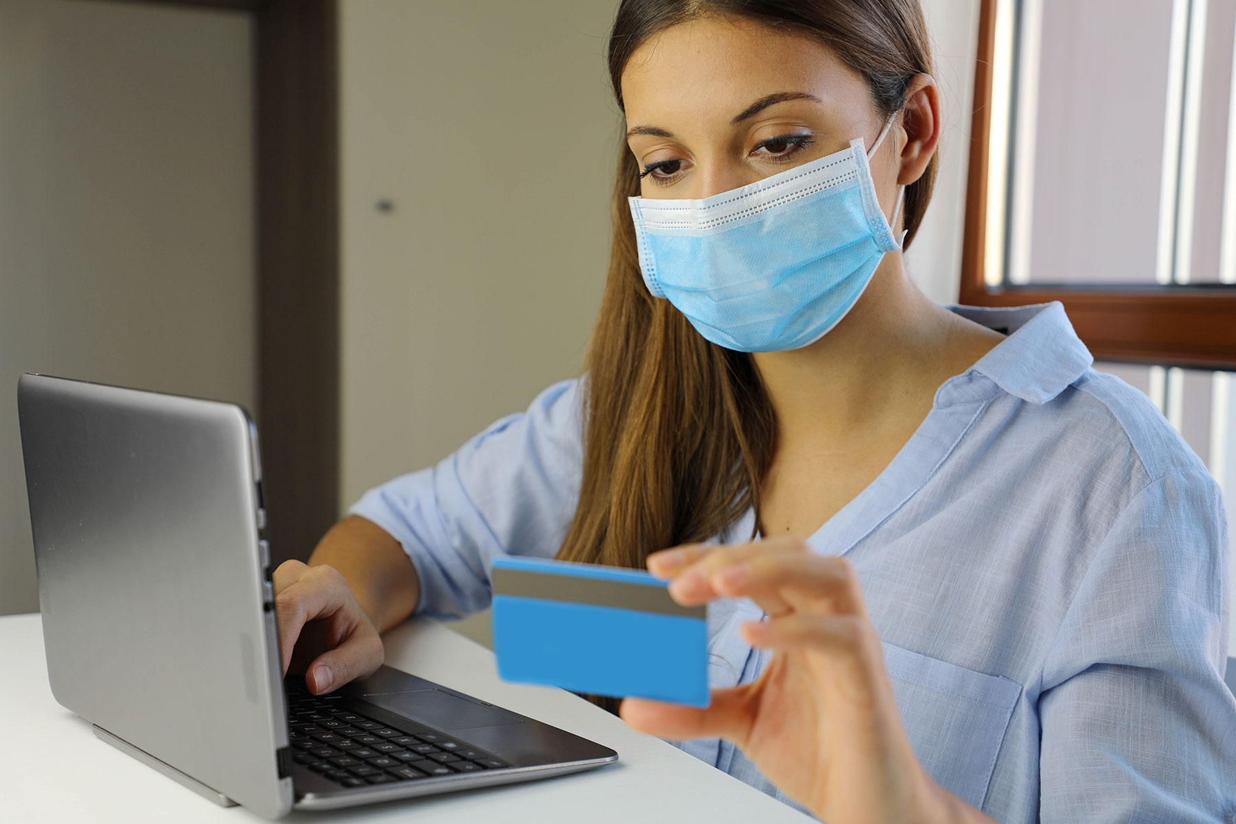 Mujer con mascarilla realizando una compra online / Gtres