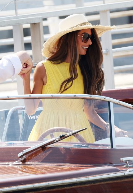 Amal clooney deslumbra en el festival de Venecia con un elegante vestido amarillo.