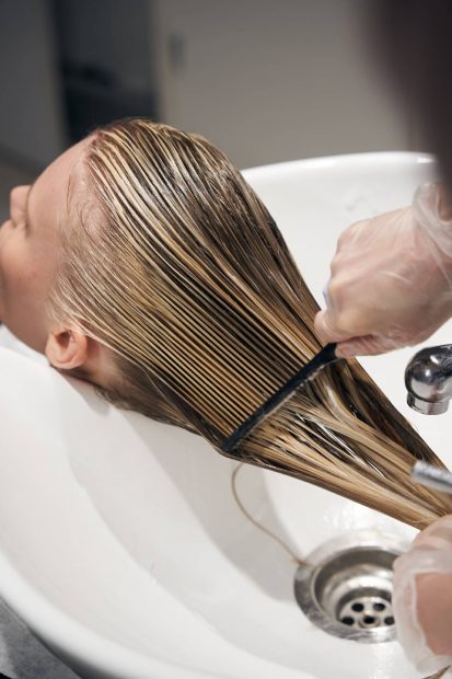 El cabello de una persona est&aacute; siendo tratado con un peine mientras se encuentra mojado. (Foto: Llongueras)