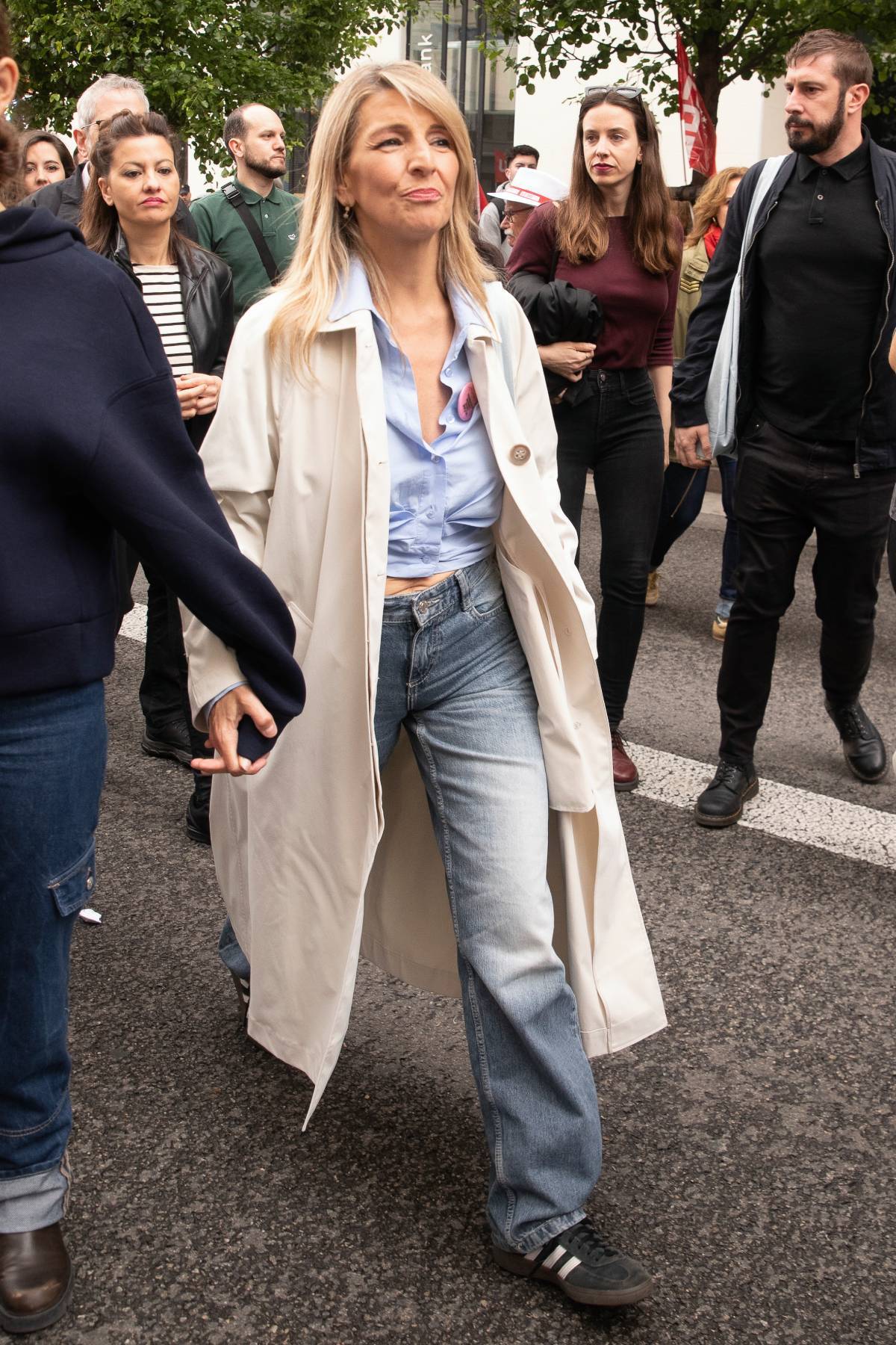 Yolanda D&iacute;az, en plena manifestaci&oacute;n, con la camisa abierta dejando ver el abdomen y caminando de la mano de su hija Carmela. (Gtres)