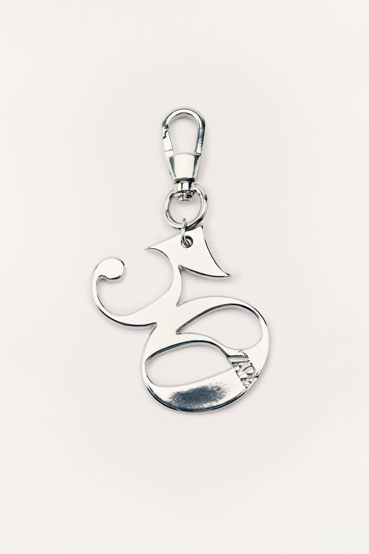 Charm de letra plateada decorativa. Zara