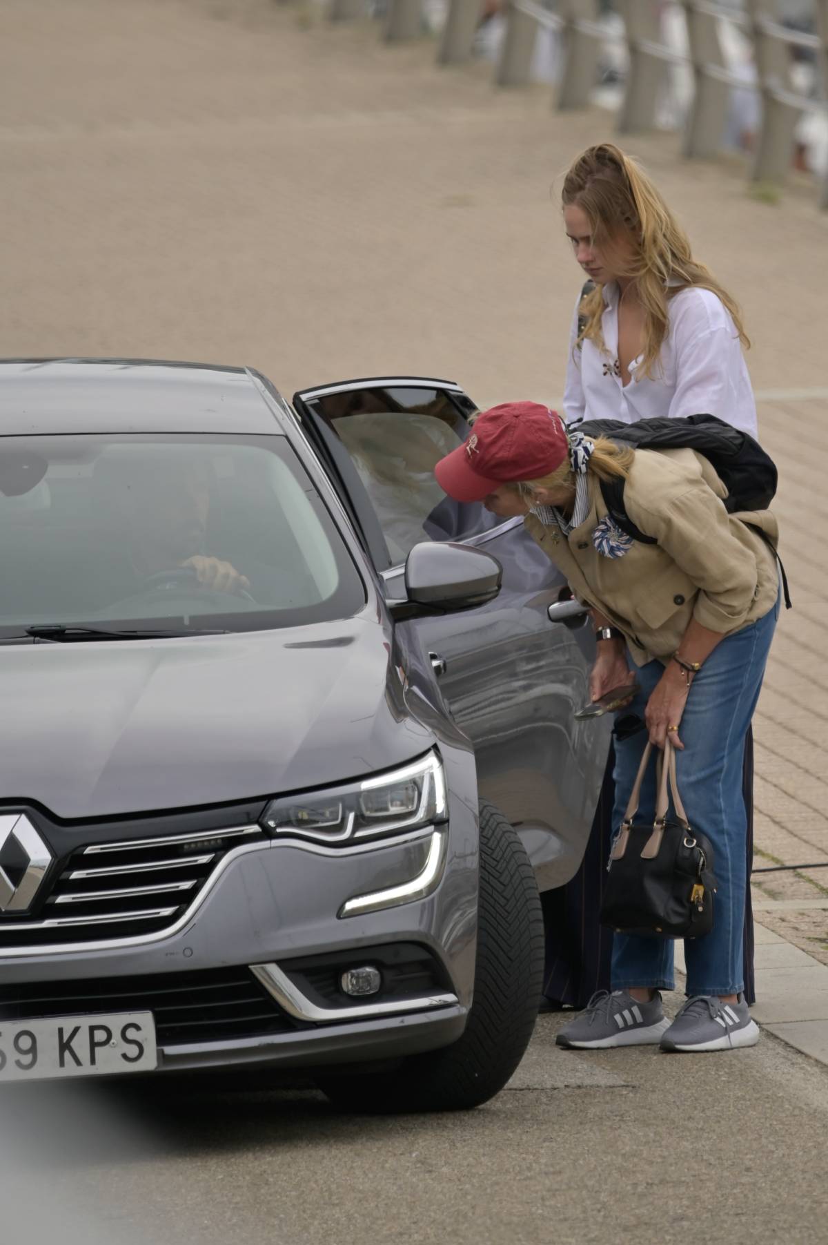 Elena e Irene, junto al coche, mientras saludaban a don Juan Carlos I. (Gtres)