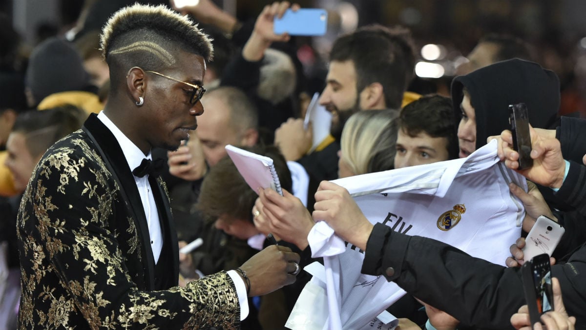 Paul Pogba firma una camiseta del Real Madrid antes de la gala del Balón de Oro. (Reuters)