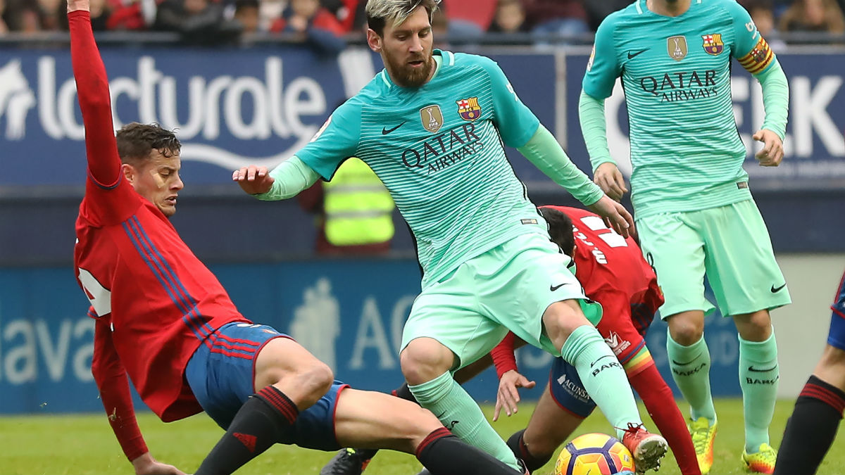 Oriol Riera entra a Messi en un partido de esta temporada. (AFP)