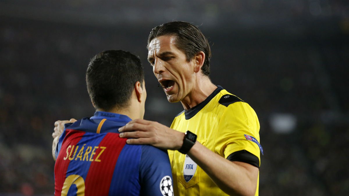 Luis Suárez habla con el árbitro durante el Barcelona-PSG. (AFP)