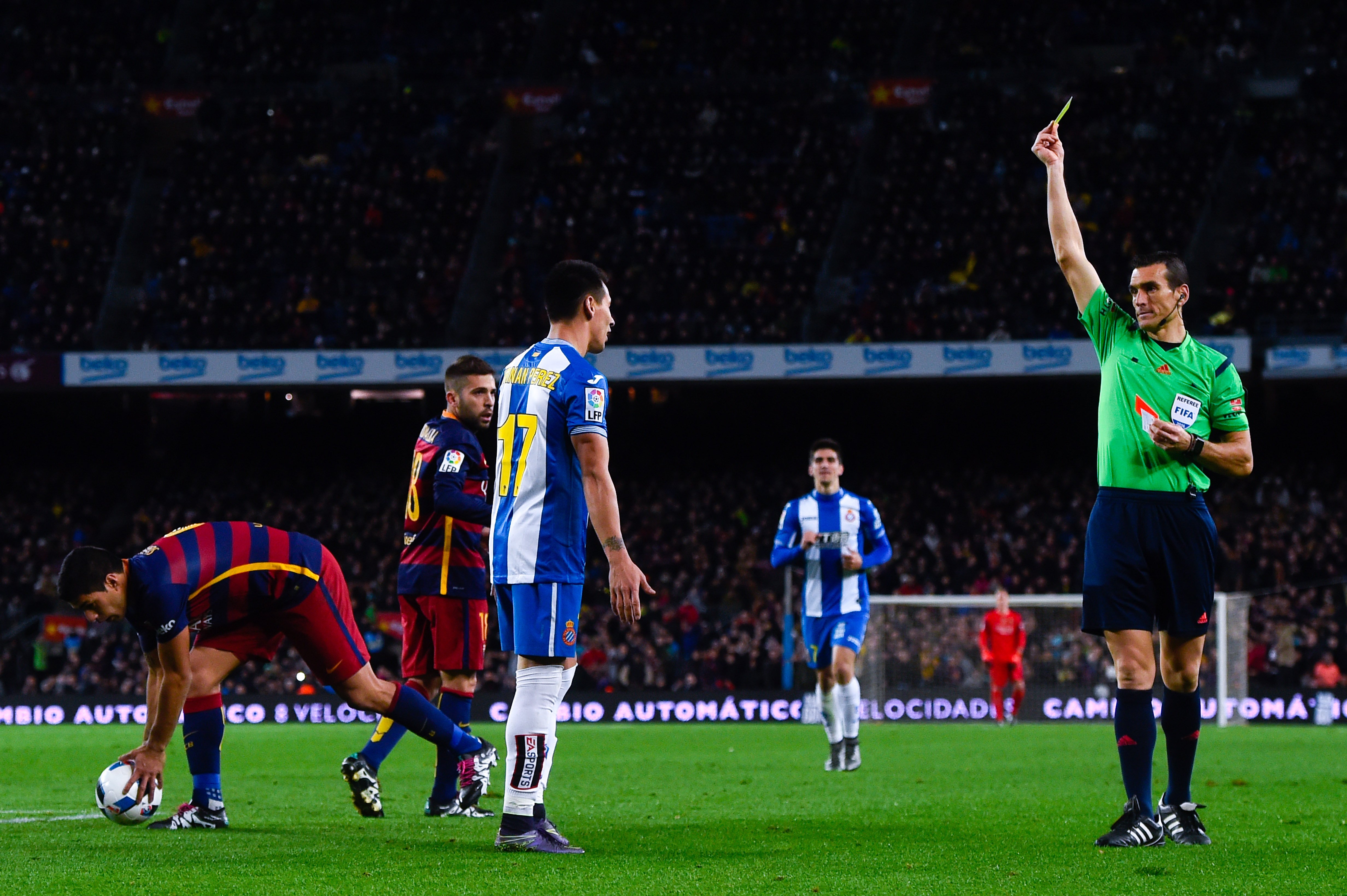 Una imagen habitual de los derbis: un jugador del Espanyol recibiendo una amarilla contra el Barcelona. (Getty)