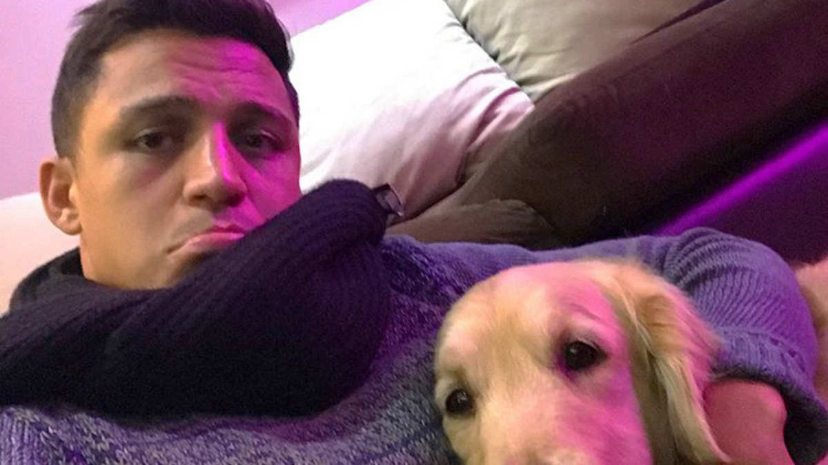 Alexis Sánchez posa con su perro en el sofá de su casa. (Instagram)