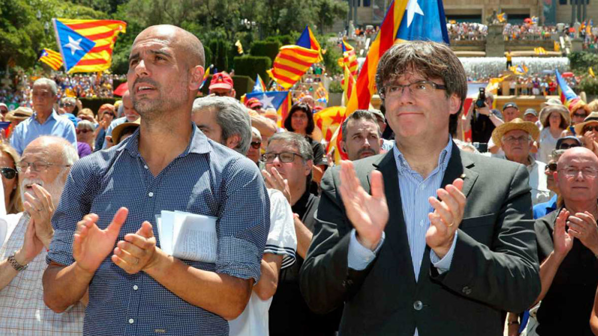 Pep Guardiola aplaude junto a su padrino Puigdemont.