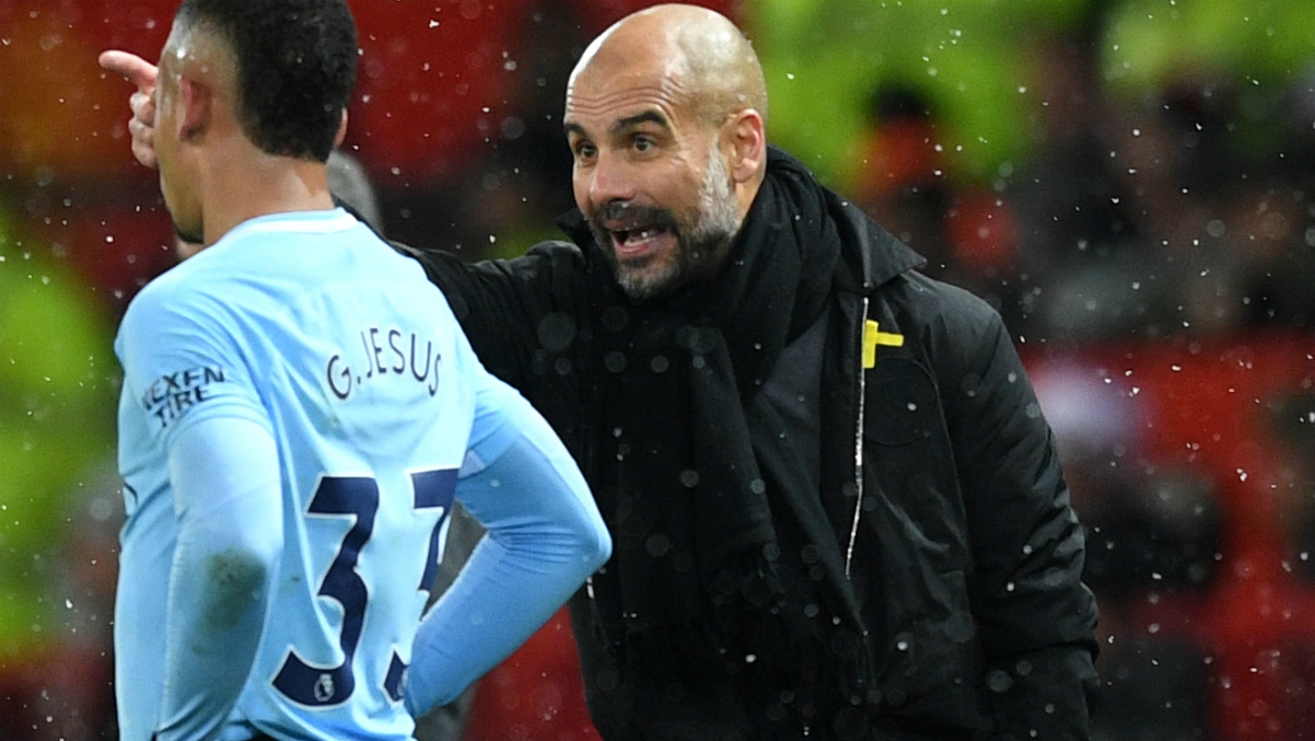 Guardiola da instrucciones a uno de sus jugadores, con el lazo amarillo en su chaqueta. (Getty Images)