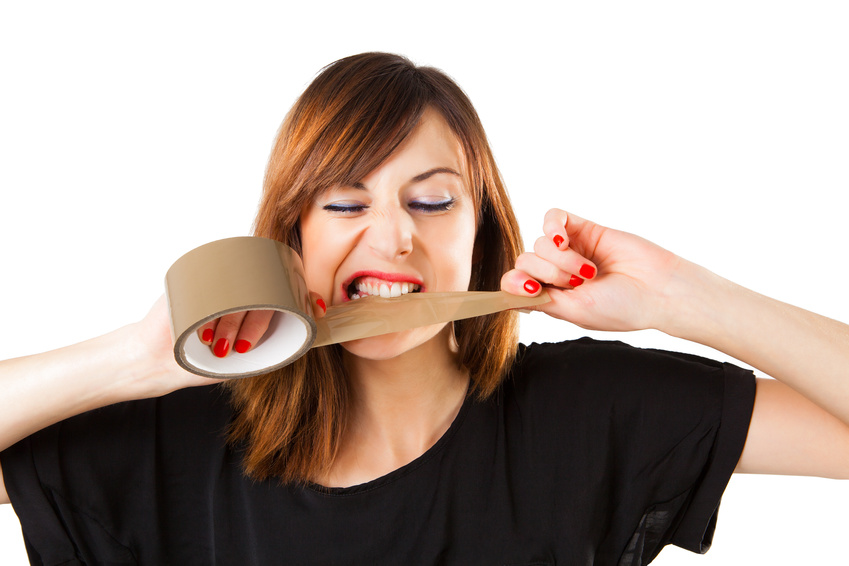 Young woman biting a tape box roll.