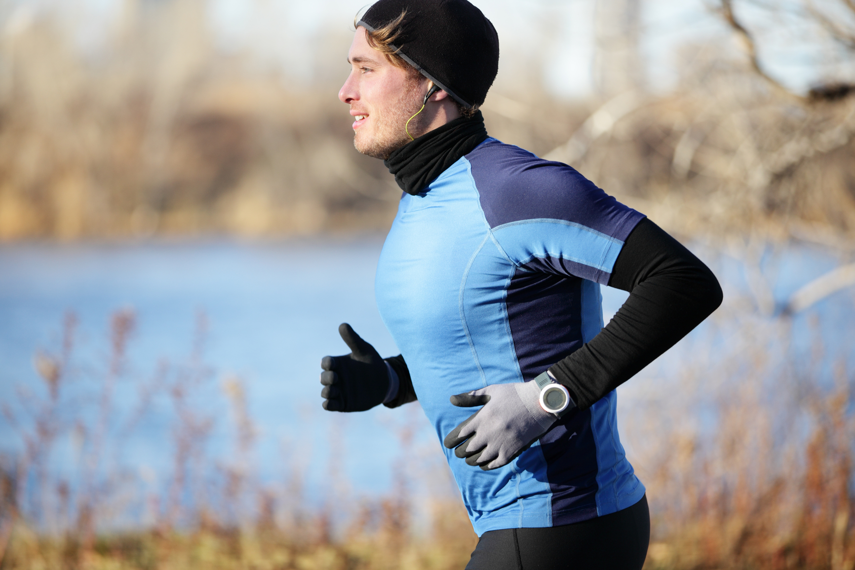 Runner man in fall running in autumn with gloves