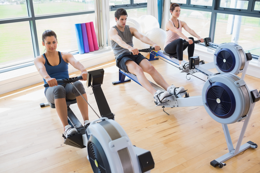 People using rowing machines in fitness studio