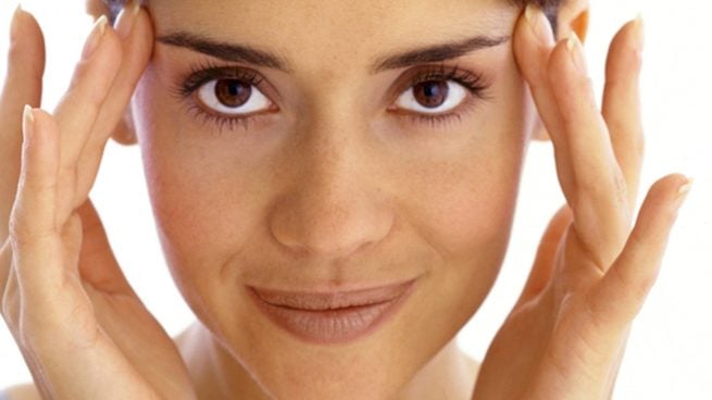 Una mujer sonríe y muestra su manicura