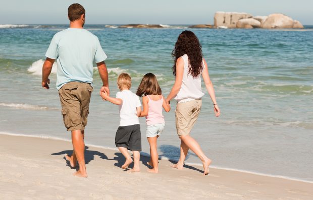 Familia paseando por la playa. / Gtres