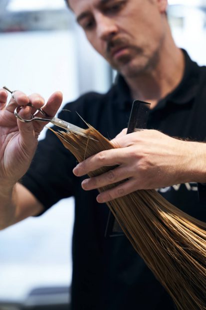 Estilista cortando las puntas de un cabello largo y mojado. (Foto: Llongueras)