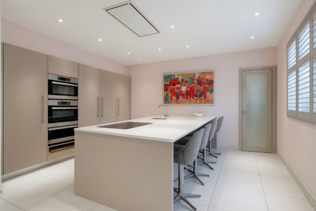 La cocina minimalista de tonos suaves con una isla central.