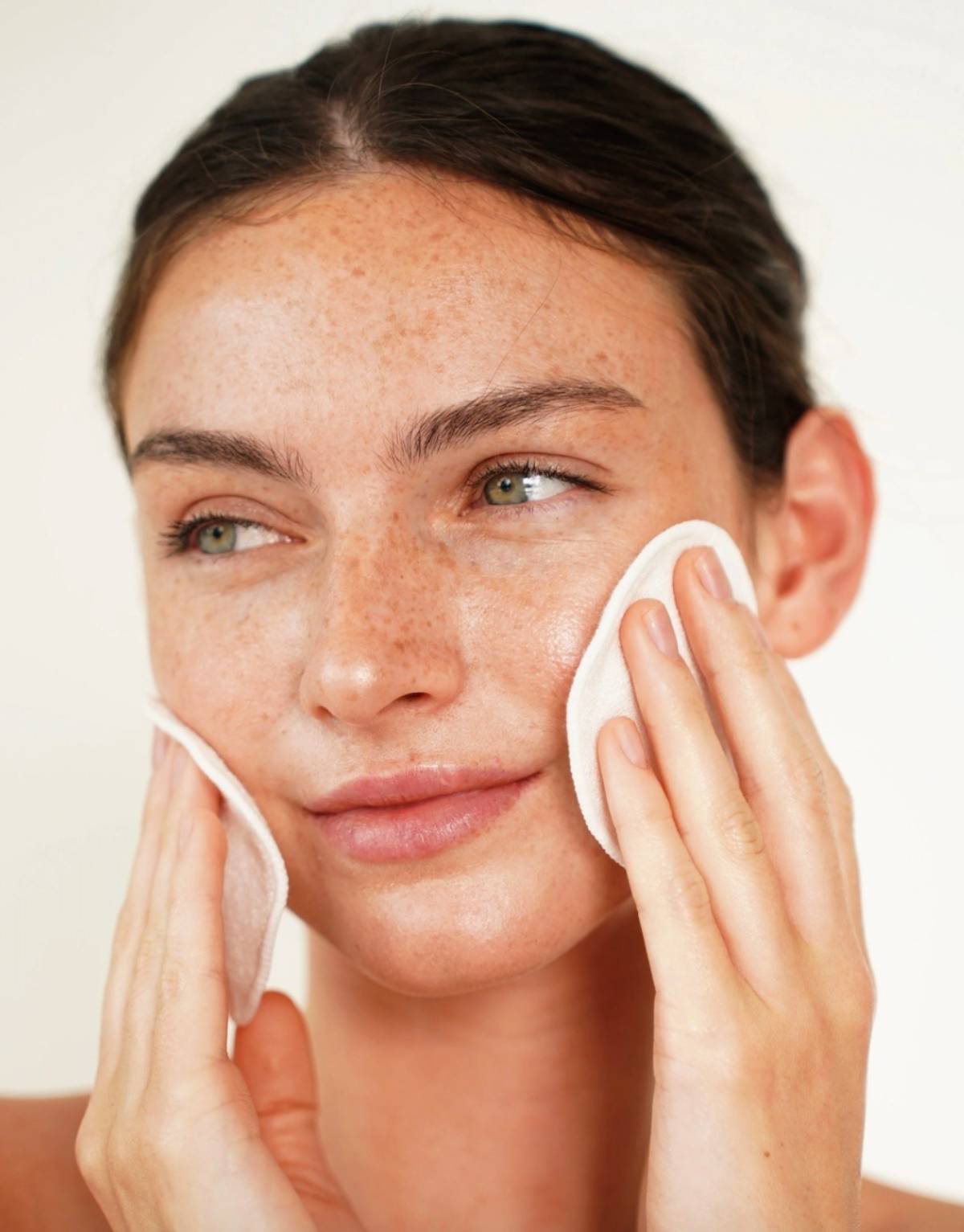 Primer plano de una mujer con piel fresca y natural aplicándose un producto con discos reutilizables. (Foto cedida por Germaine de Capuccini)