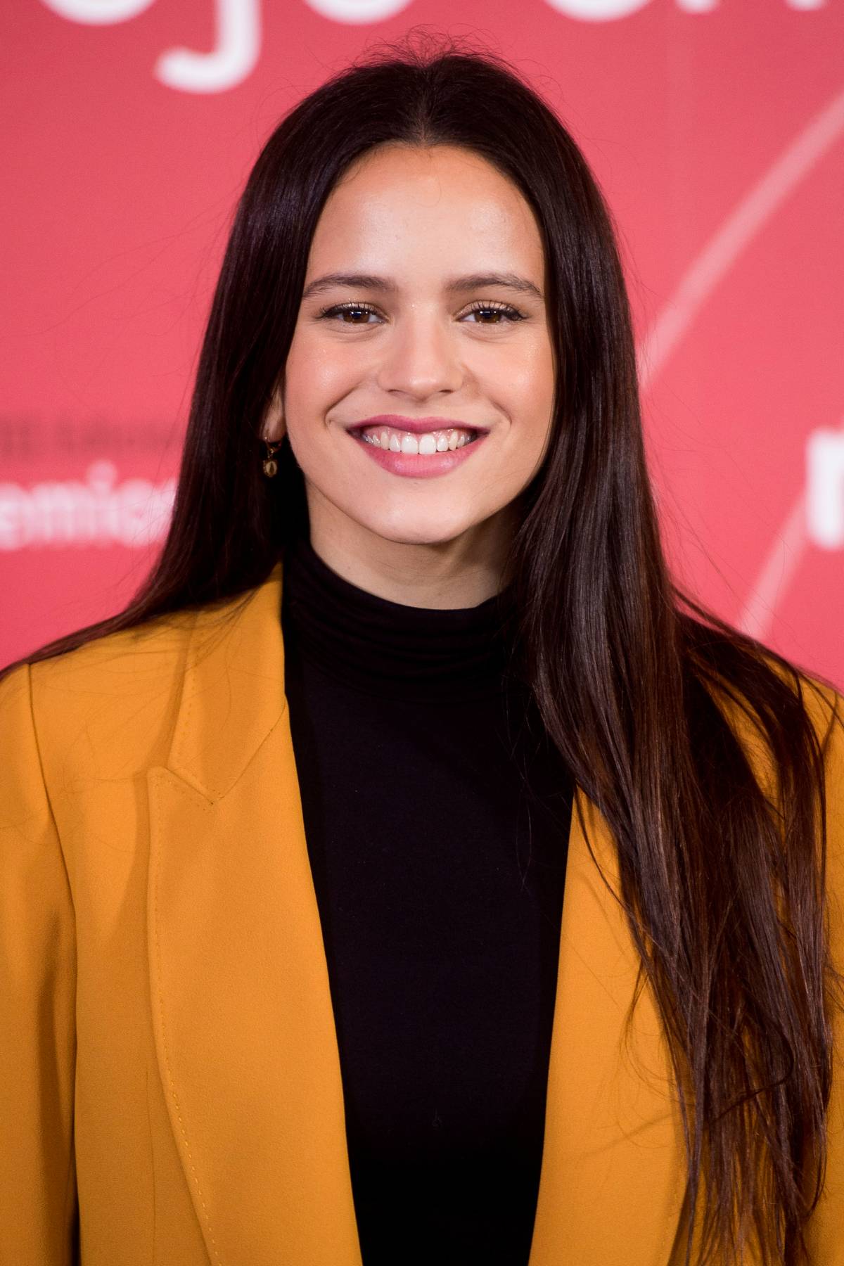 Rosalía durante una presentación pública, con un estilismo en tonos cálidos y gesto sonriente. (Foto: Gtres)