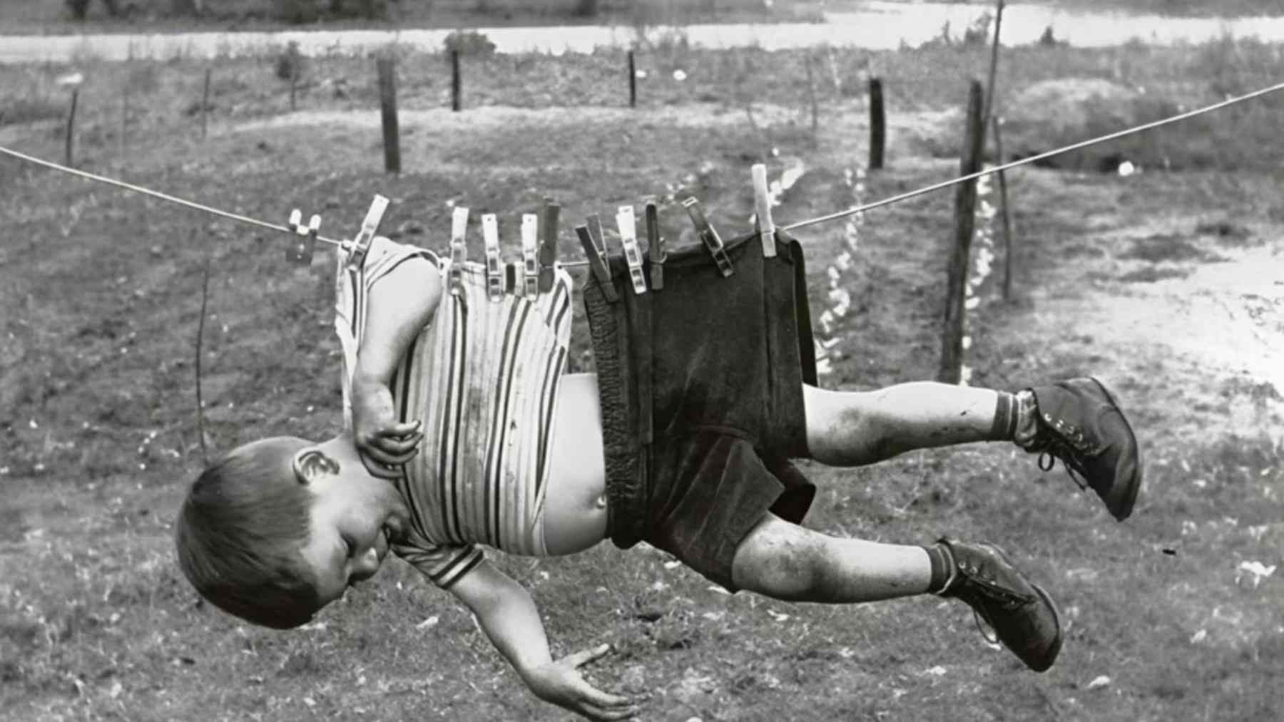 1970s child drinking from a garden hose outdoors, symbolizing independent childhood and resilience