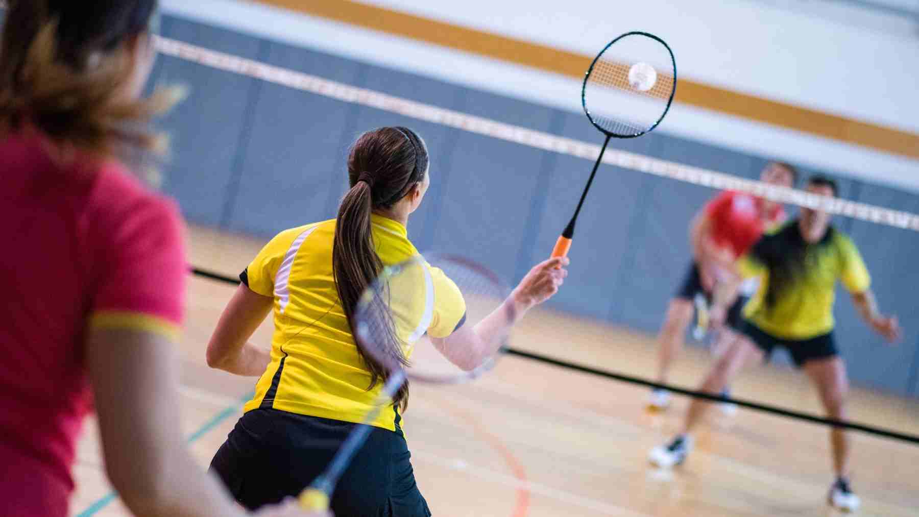Badminton players in action showing how core stability supports power and balance in racket sports