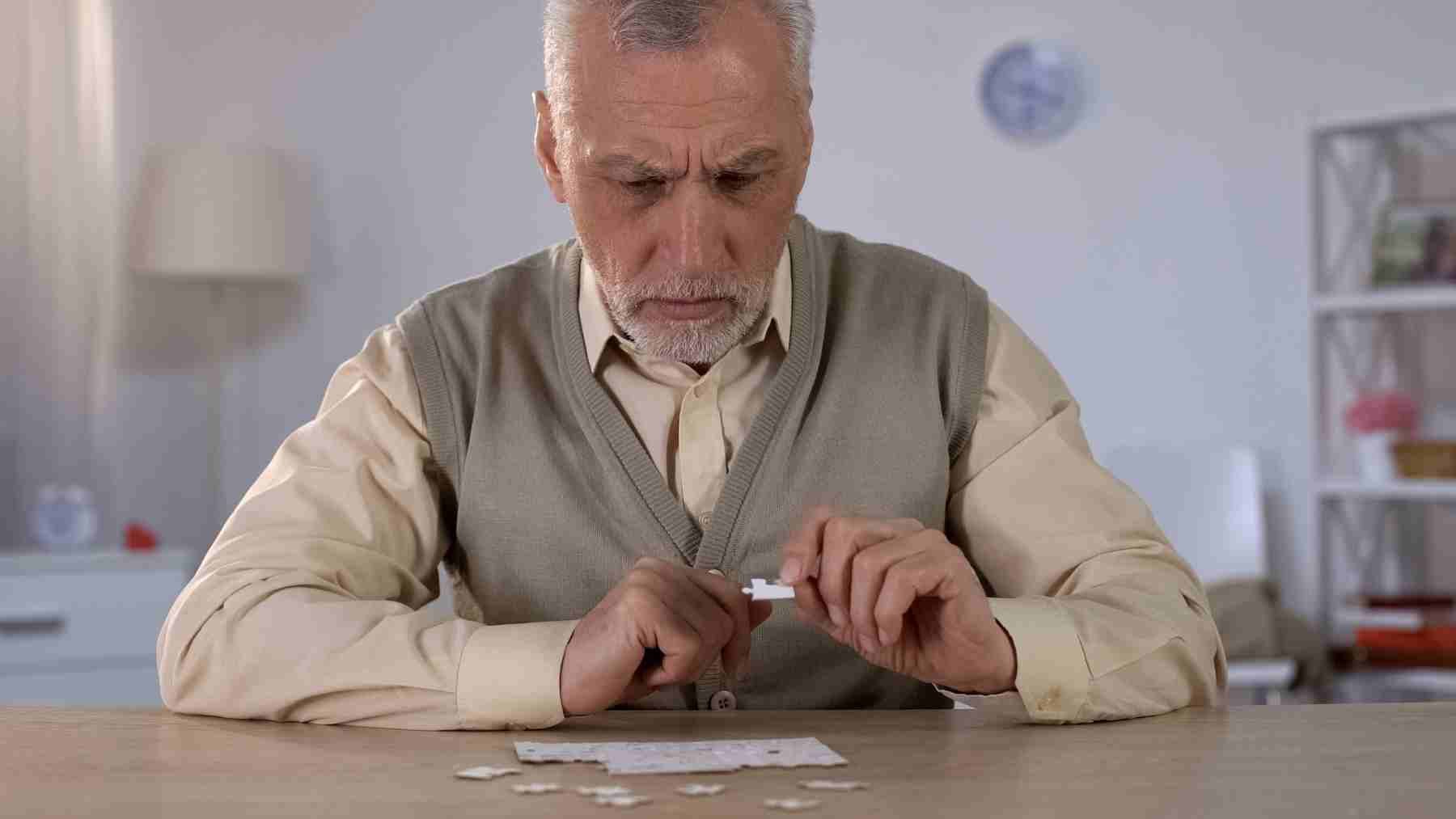 Older man concentrating on puzzle pieces, symbolizing early memory lapses and cognitive decline detection