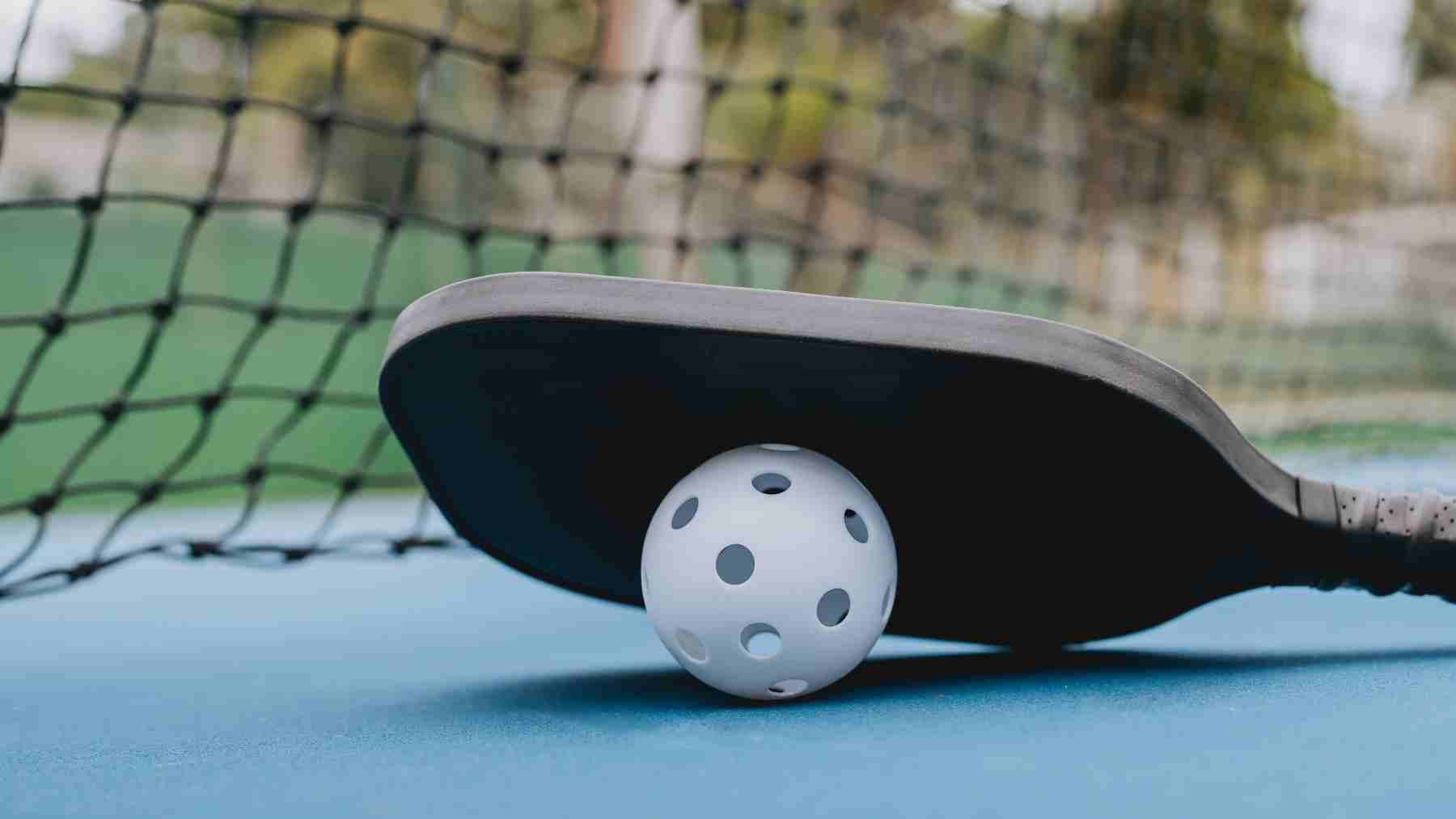 Pickleball paddle resting on a ball on court during mental well-being study of 1,667 U.S. adults