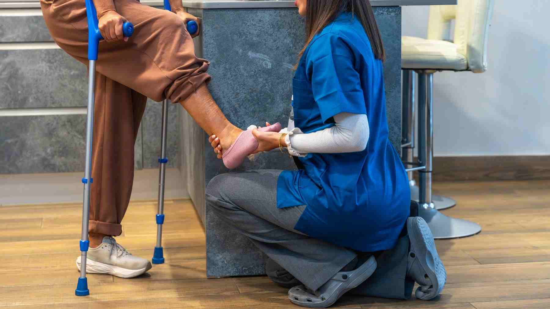 Physical therapist examining a runner’s injured foot after training-related overuse injury