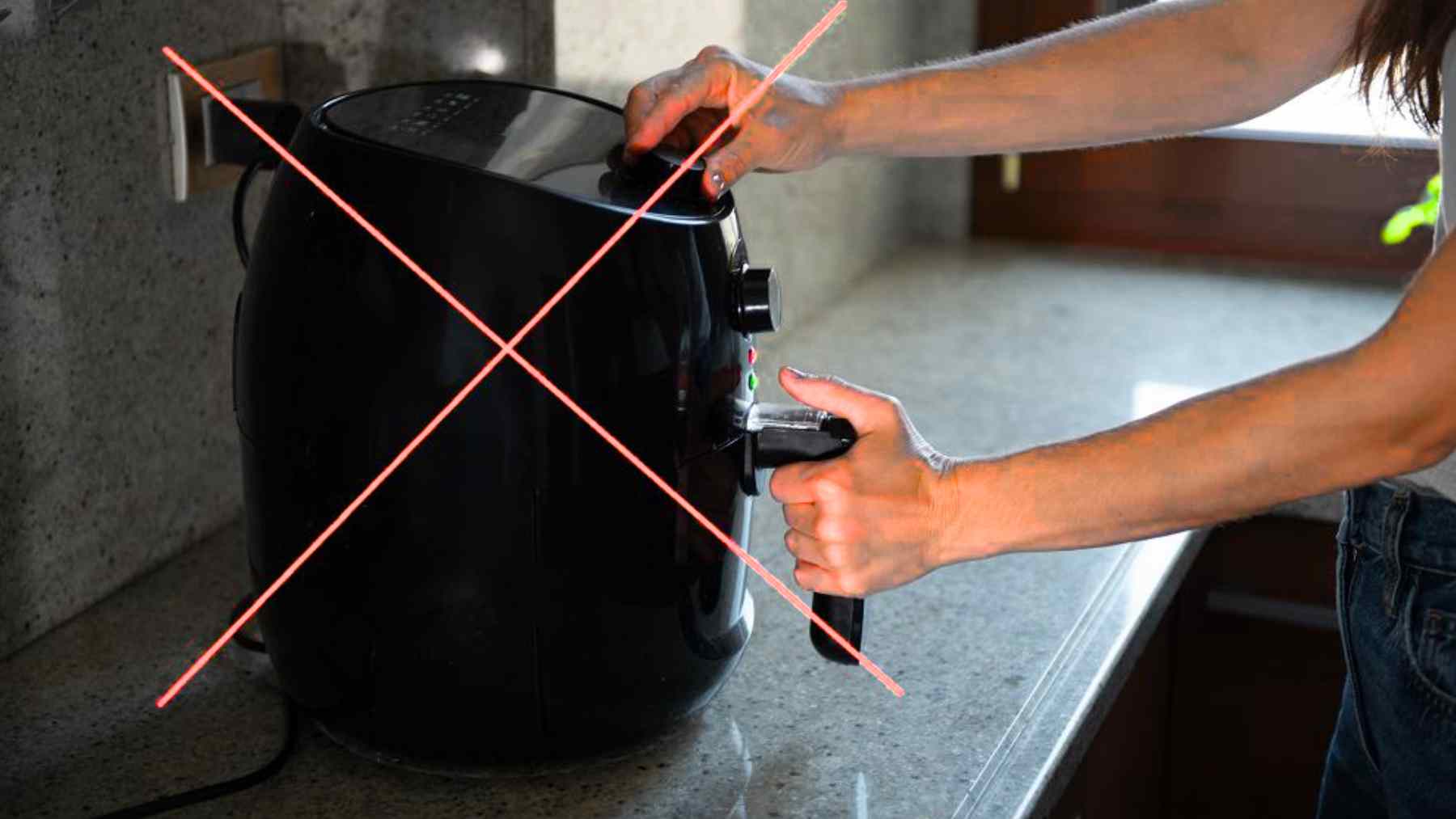 Person using a black air fryer crossed out to show a new infrared countertop oven trend for healthy home cooking