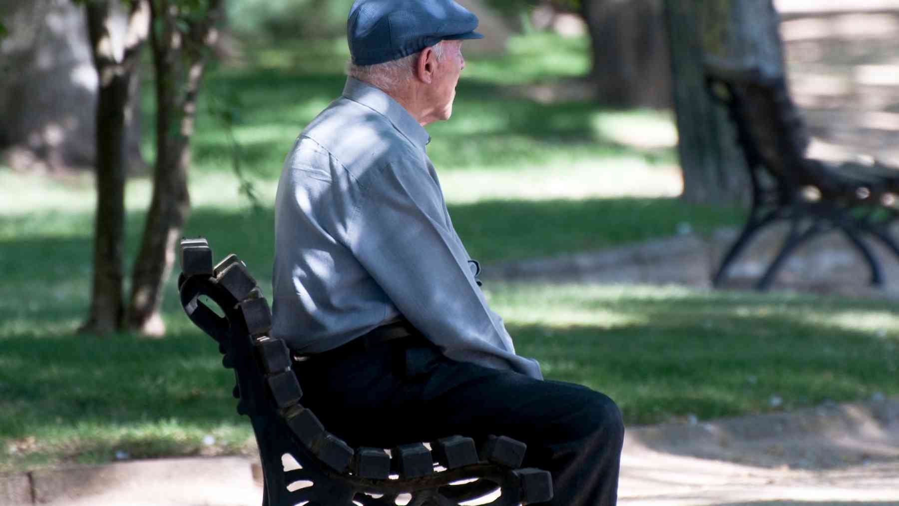 Older man sitting alone on a park bench, reflecting on loneliness in later life and the need to feel remembered.