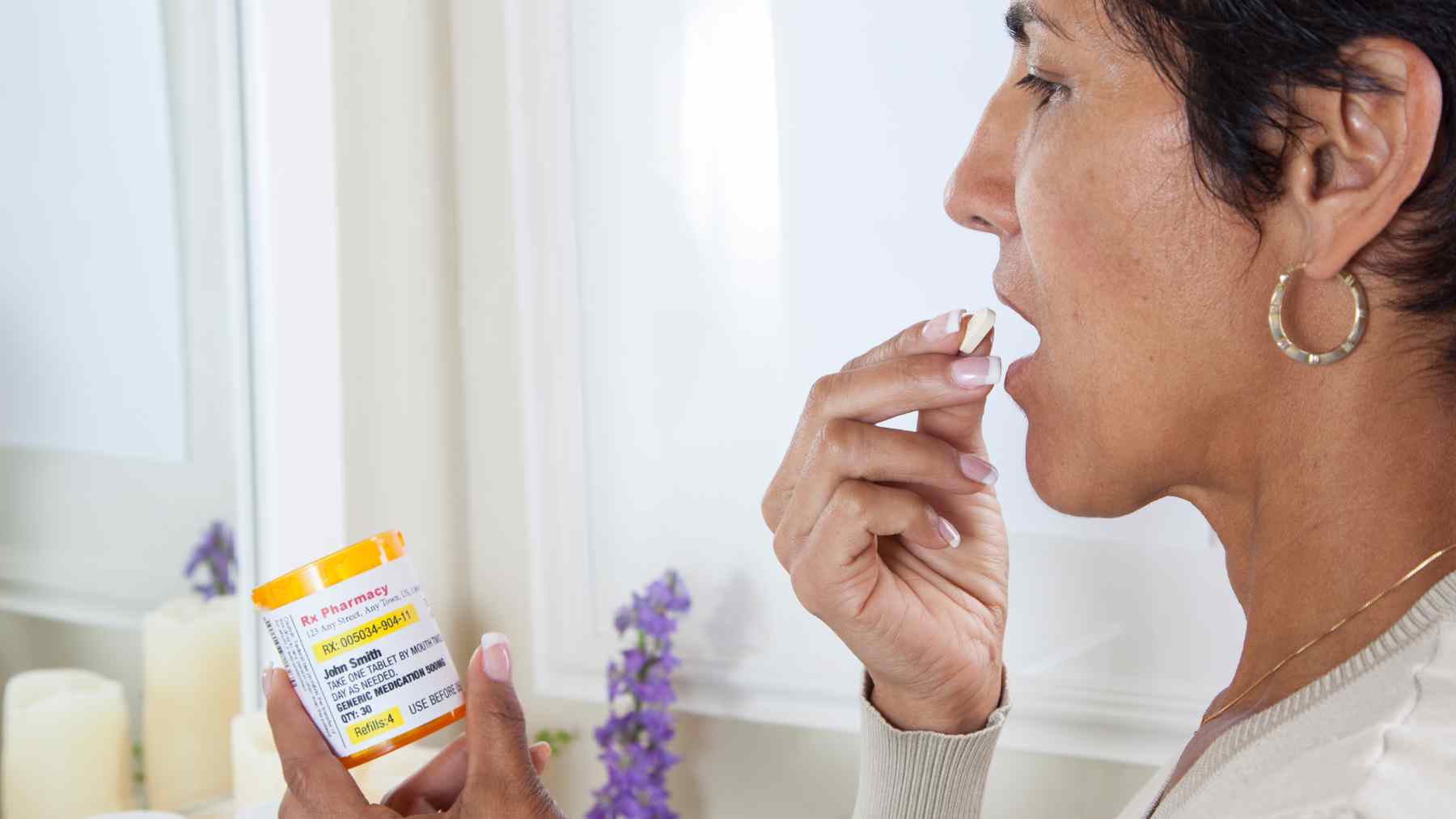 Woman taking a sleep supplement while holding a pill bottle, illustrating concerns about long-term melatonin use and heart failure risk