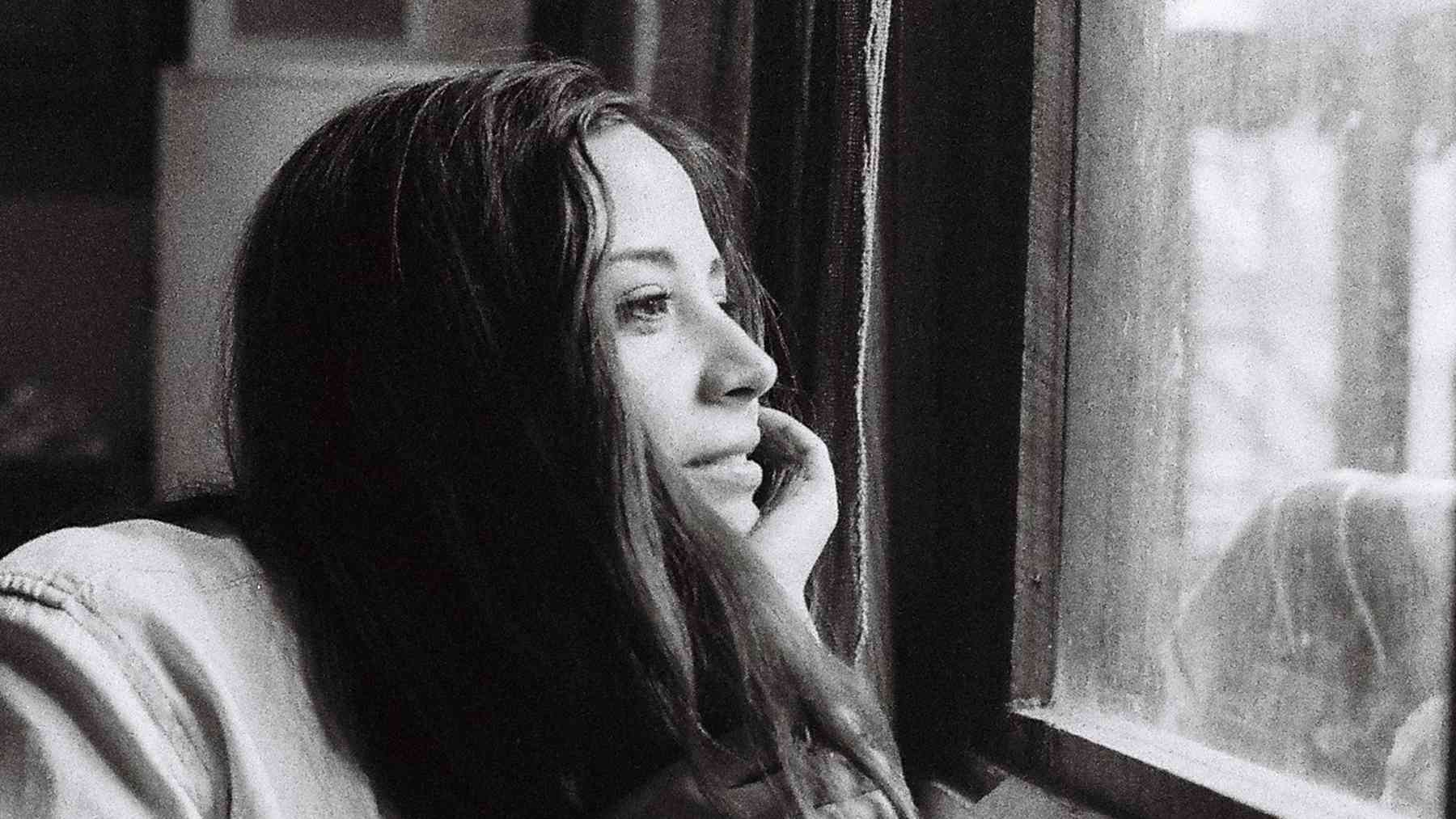 Woman looking thoughtfully out a window while reflecting on patience, stress, and emotional self-control