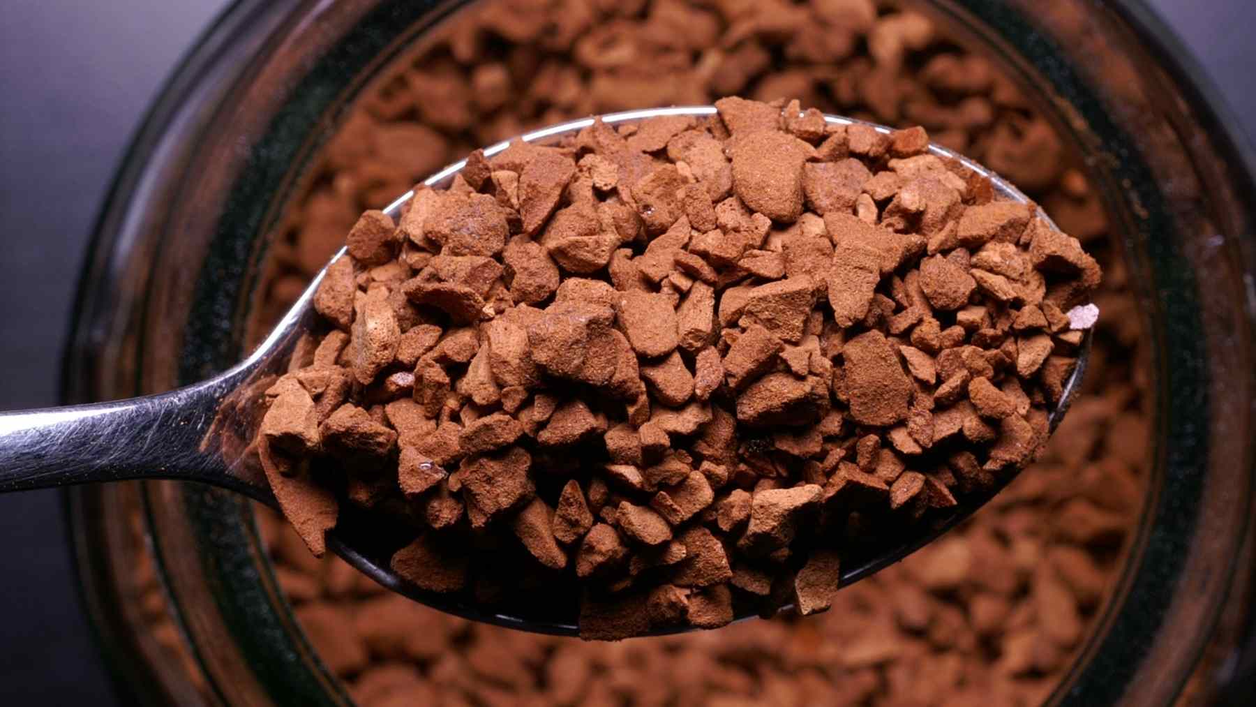 Spoonful of instant coffee granules over a jar after supermarket coffee beat Nescafé in a blind taste test.