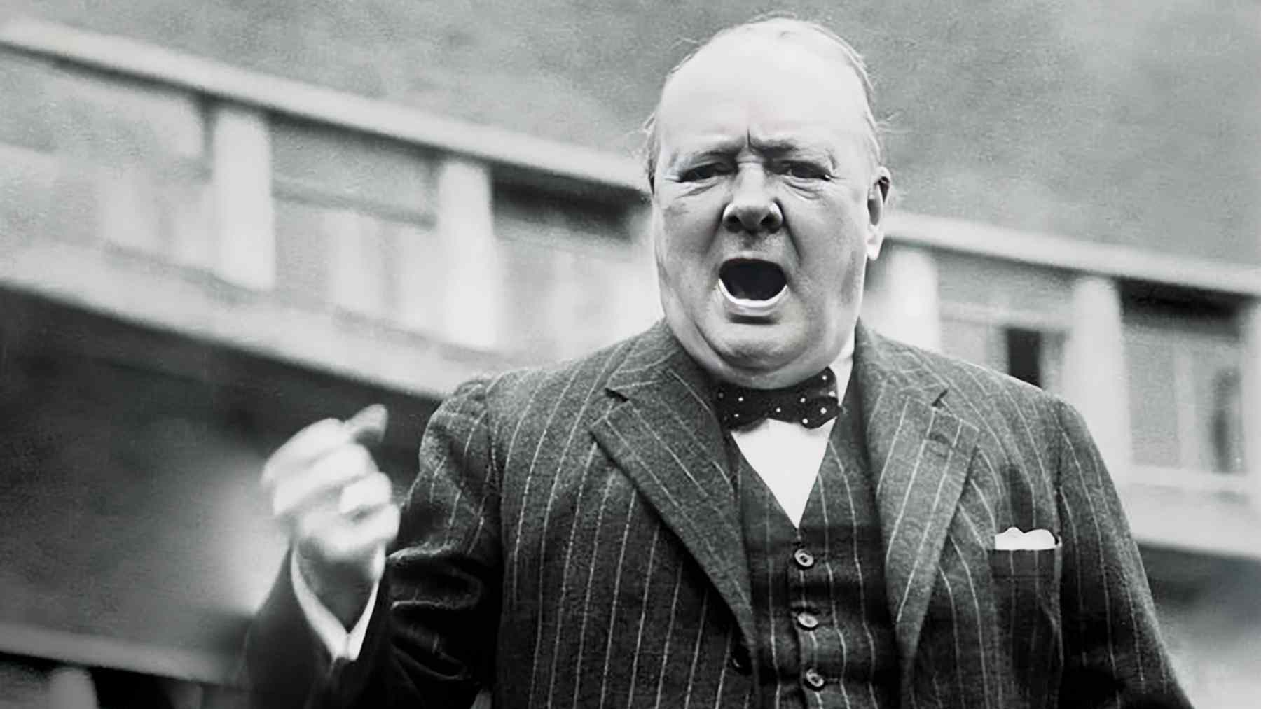 Black-and-white photo of a historical statesman speaking in public, tied to a disputed Churchill quote about courage and listening