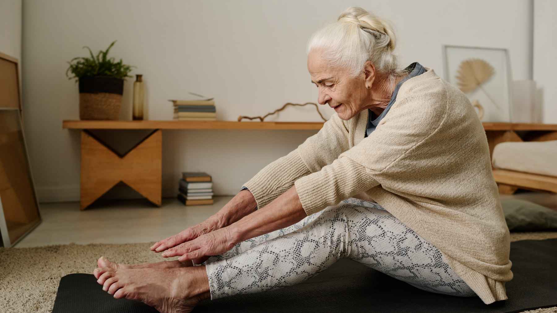Older woman performing strength and Pilates exercises as part of a fitness routine focused on longevity, mobility, and healthy aging.
