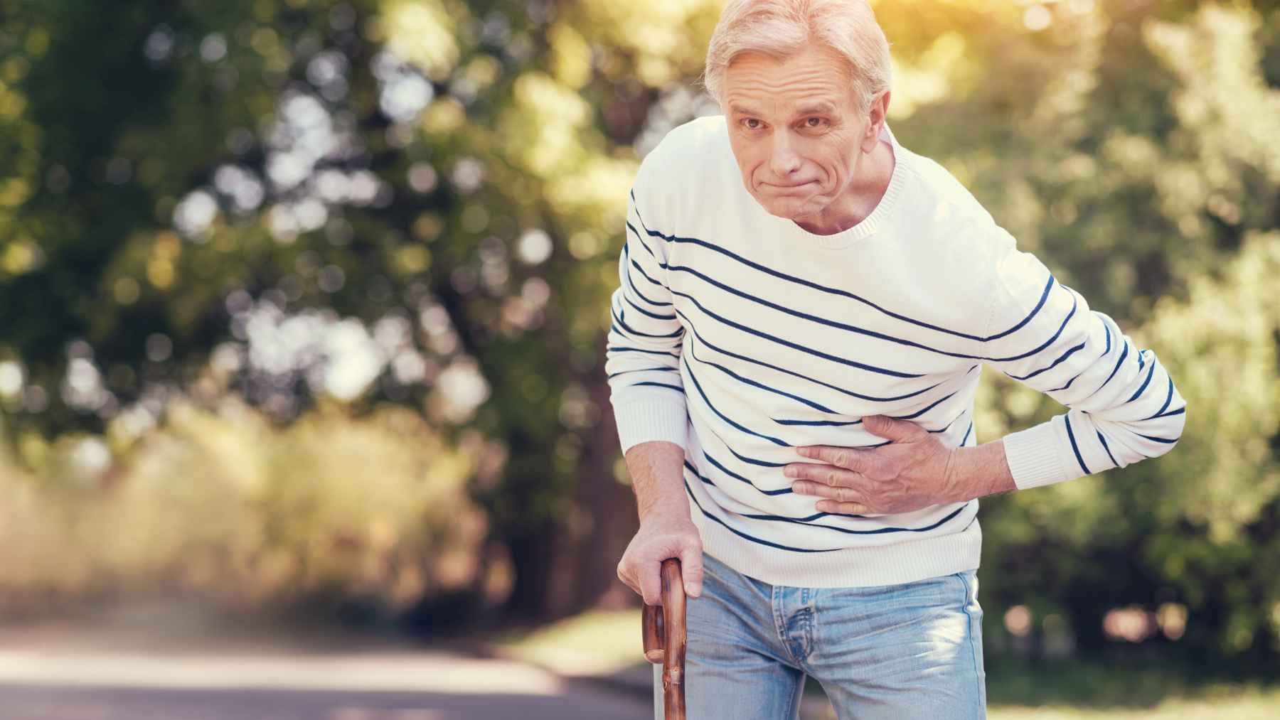 Older adult walking outdoors with a steady gait, illustrating how aging changes walking patterns, balance, and lower-body stability.