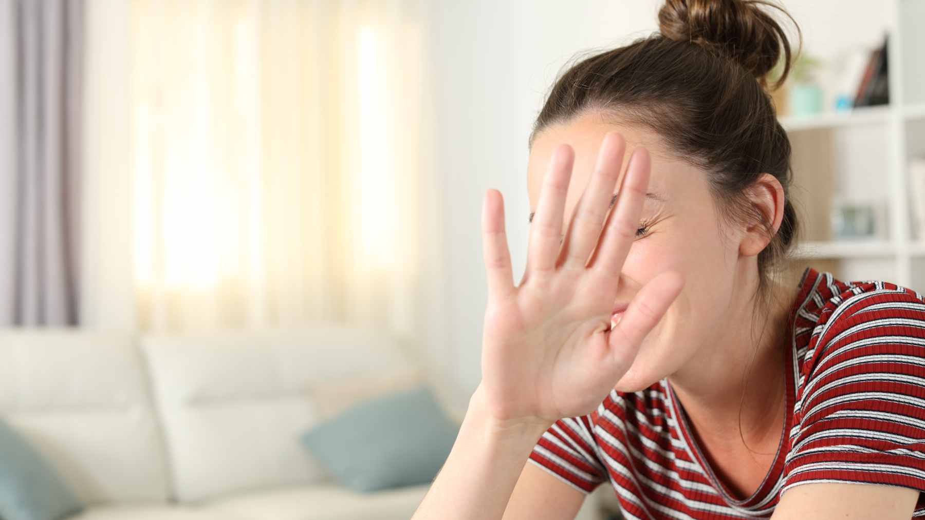 A person sitting at a desk looking visibly stressed and hesitant while staring at a calendar, representing the difficulty of coping with sudden changes.