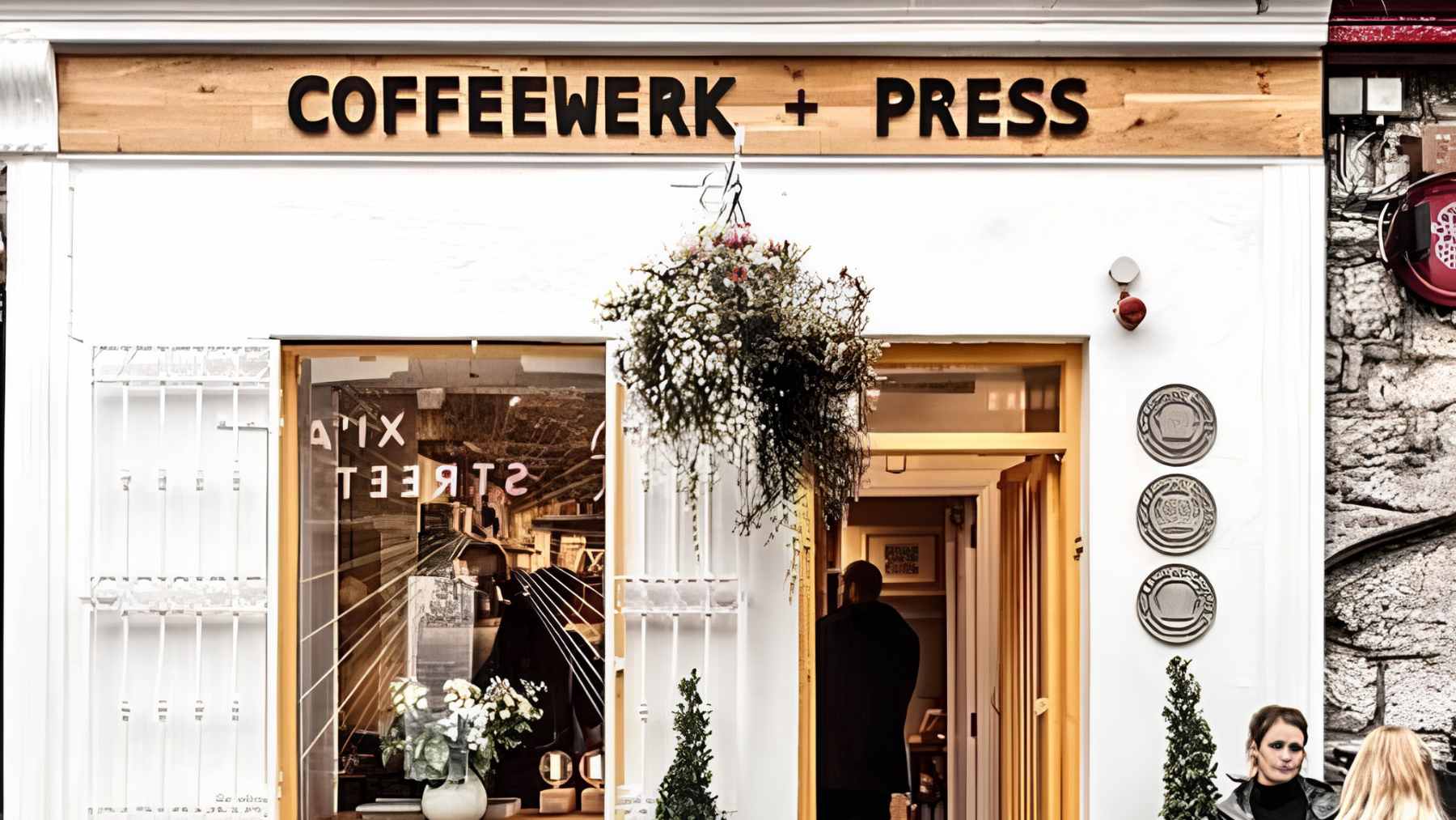 A carefully crafted pour-over coffee being served in a cozy, modern specialty cafe setting.
