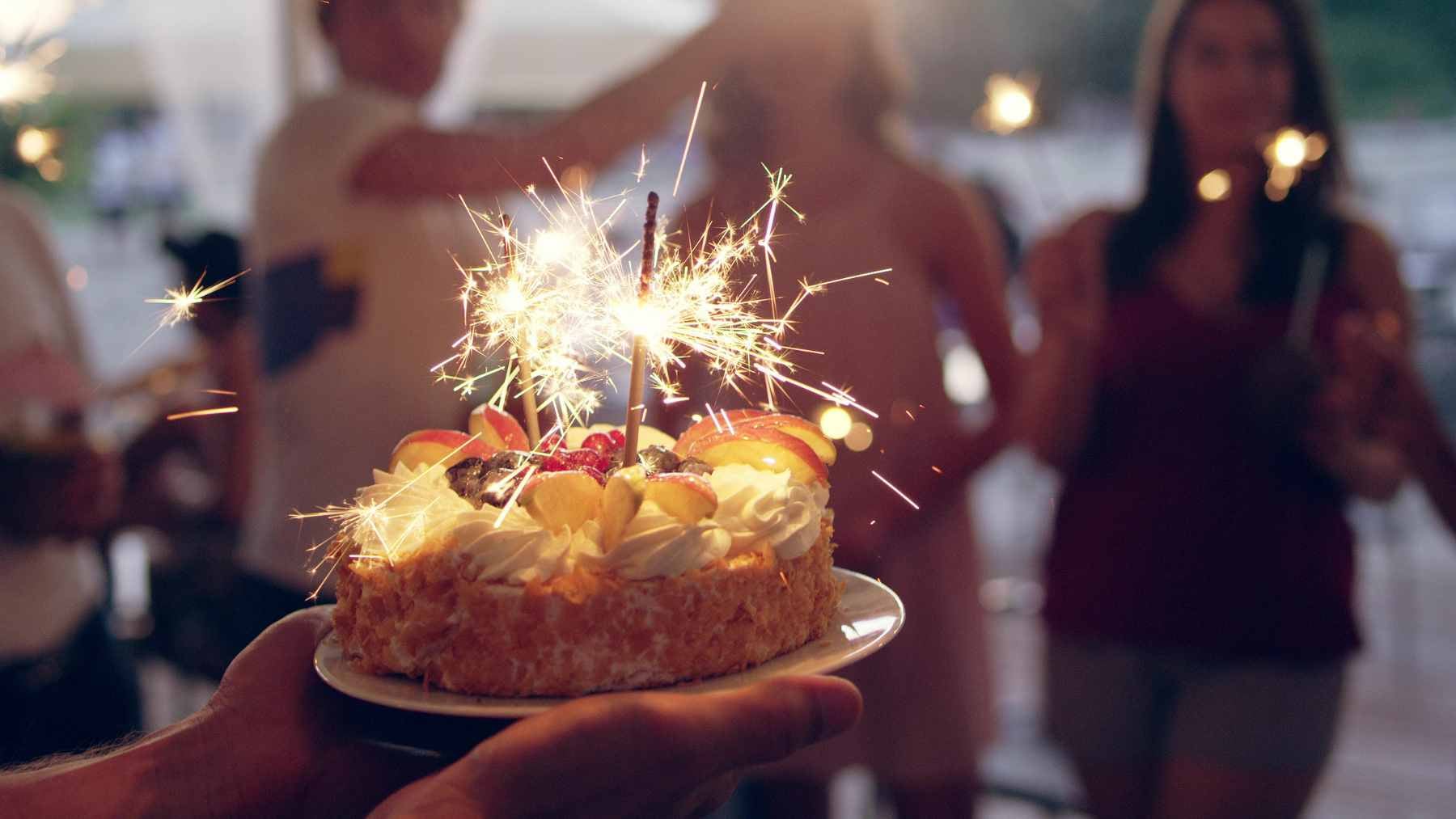 A person sitting calmly at a table with a laptop and coffee, choosing a quiet birthday over a celebration, emphasizing personal autonomy.