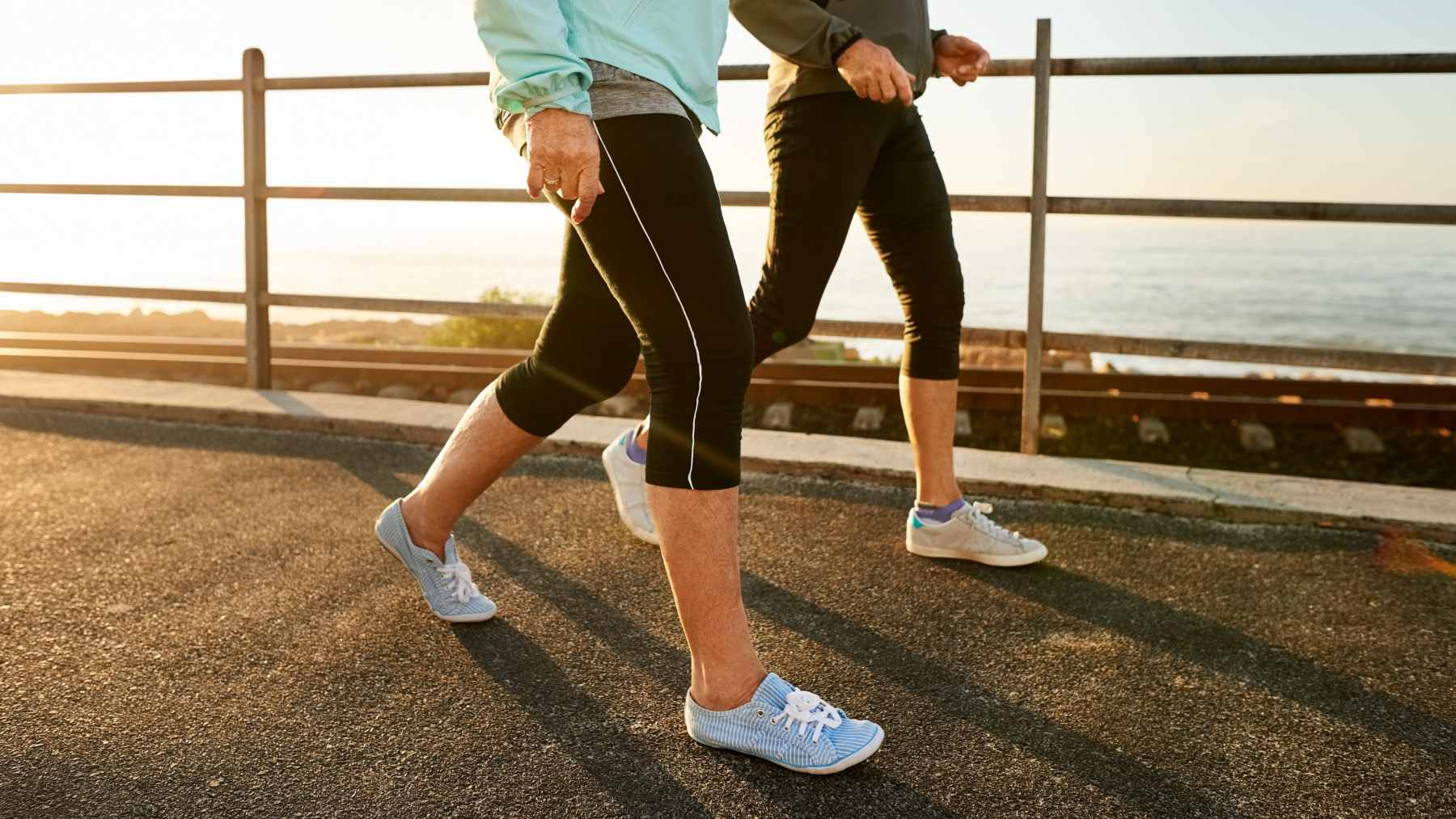 Walking may help you more than the gym, but only if you do it this specific way 1 A person walking briskly on a sunny park path, maintaining a steady pace to maximize aerobic fitness benefits.